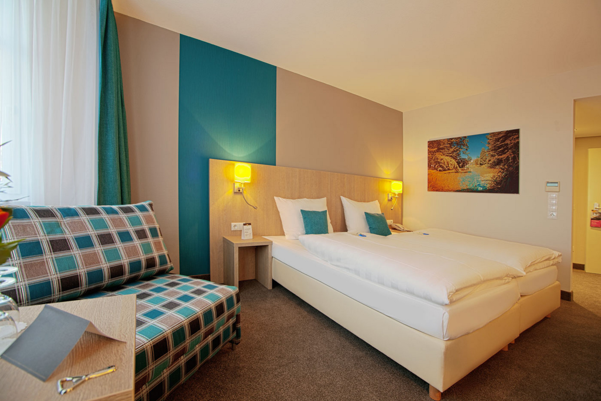 Deluxe Doppelzimmer im Hotel mit bequemem Bett, Sitzbereich und warmem Licht 