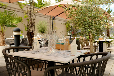 Terrasse des Hotelrestaurants mit gedecktem Tisch im Grünen