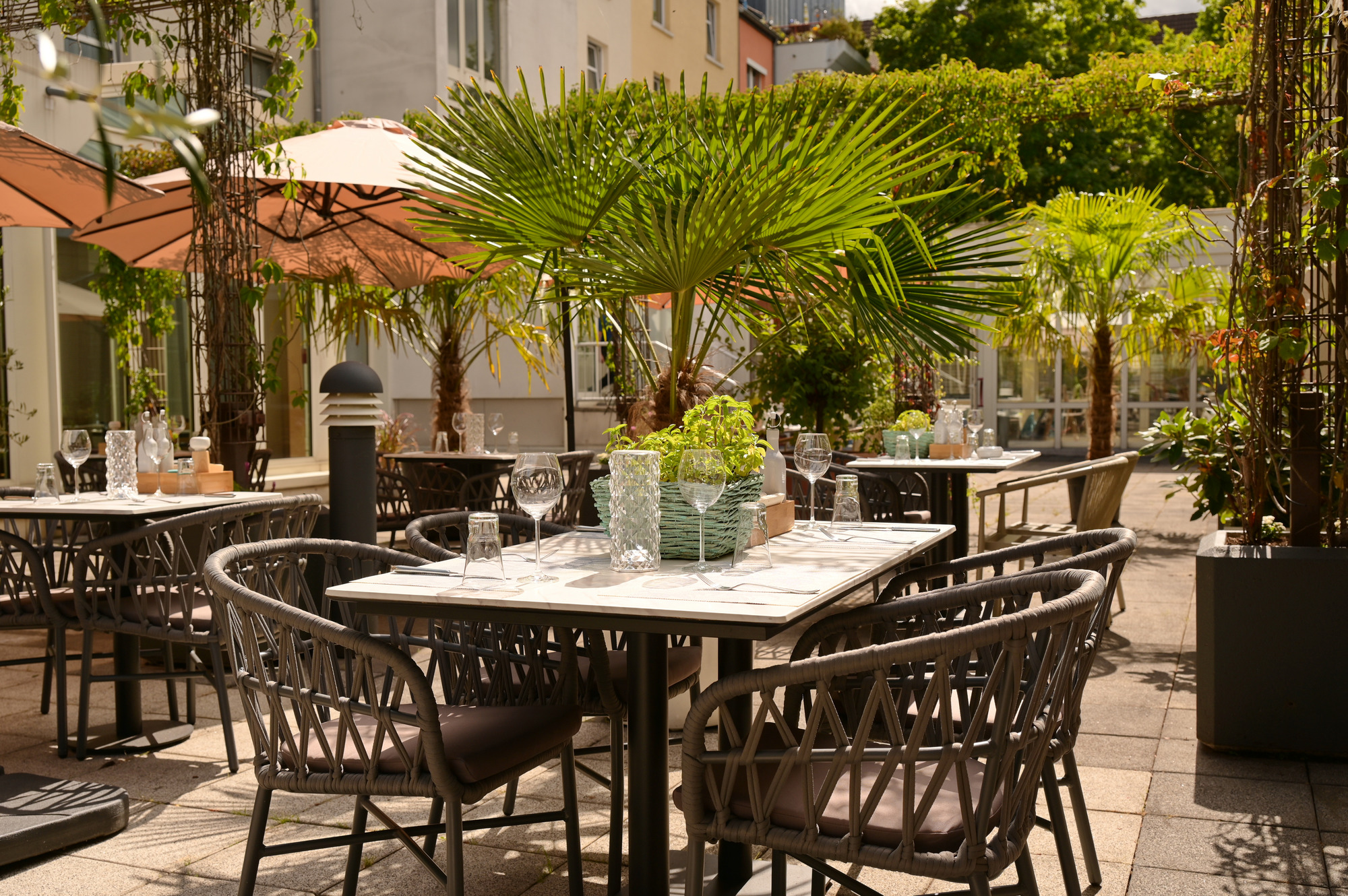 Terrasse des Hotelrestaurants mit gedecktem Tisch im Grünen