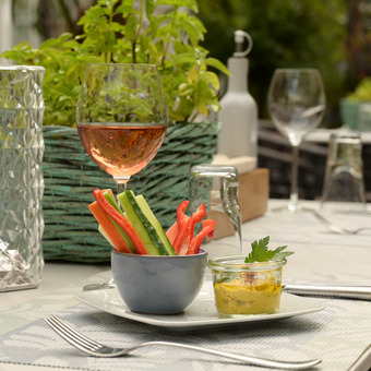 Vorspeise und Weinglas auf einem gedeckten Tisch auf der Terrasse des Hotelrestaurants